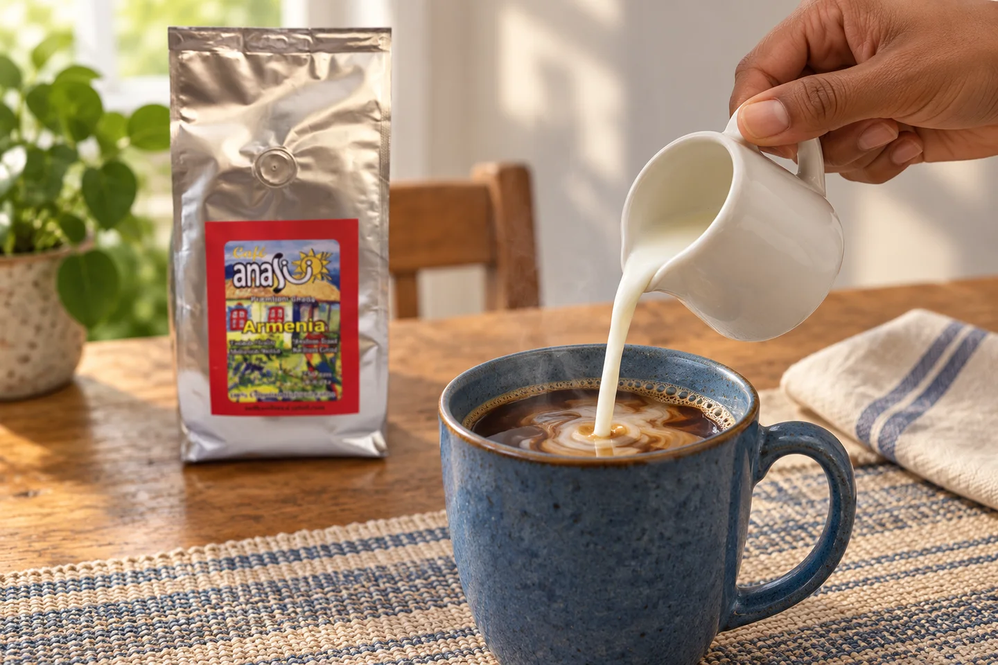 Milk poured into a blue mug of coffee with an ANASU Armenia bag in the background